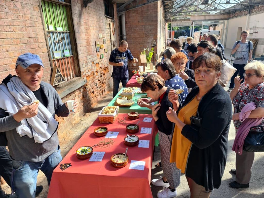 Udeleženci krožka si ogledujejo mizo na tržnici z različnimi jedmi