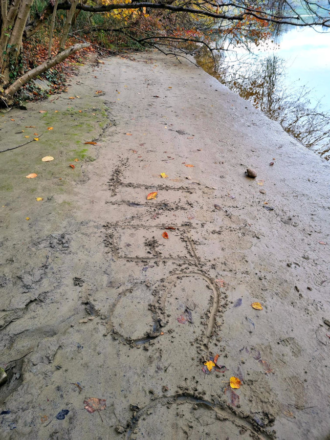 S palico vrezan napis na blatni cesti